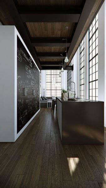 Modern loft kitchen with tall industrial windows, dark wooden flooring, and a sleek island.