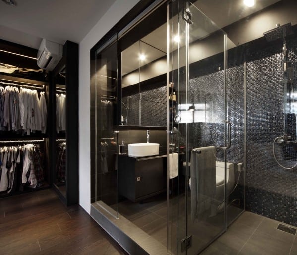 Modern bathroom with glass shower enclosure, sink, and adjacent walk-in closet