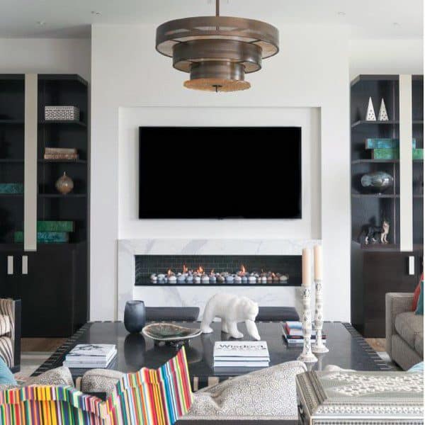 Gas fireplace with a sleek black frame, white marble surround, and decorative stone accents.