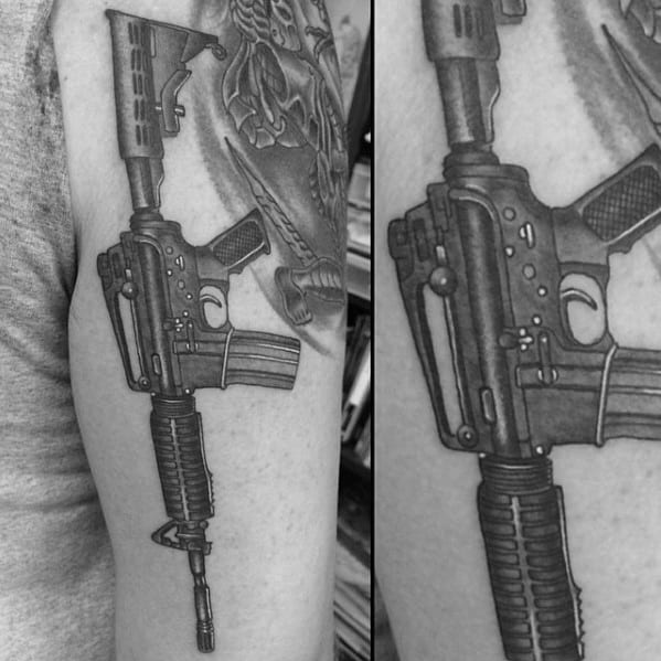 Black and grey AR-15 tattoo on the upper arm, featuring detailed shading and fine linework, symbolizing strength, precision, and tactical readiness.