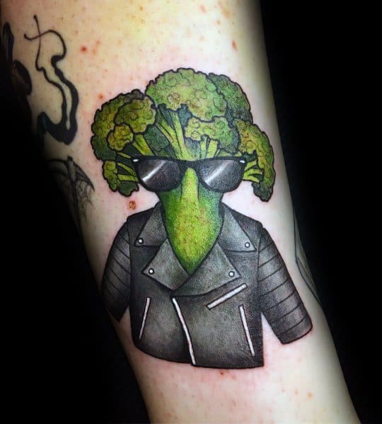Cool broccoli tattoo wearing sunglasses and a leather jacket, featuring bold colors and shading for a fun and edgy design.