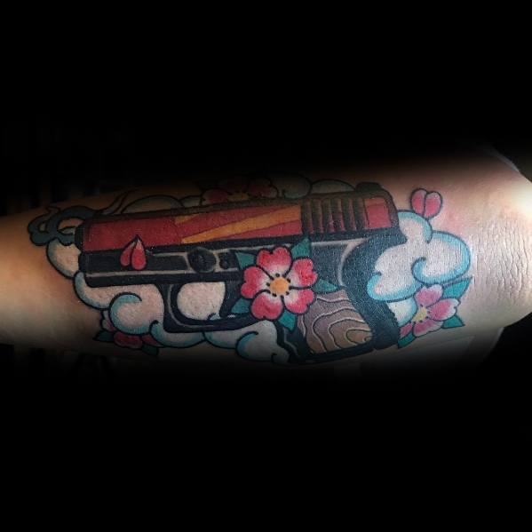 Colorful tattoo of a Glock pistol with a red slide, surrounded by cherry blossoms and clouds, blending firearm imagery with a traditional Japanese style.