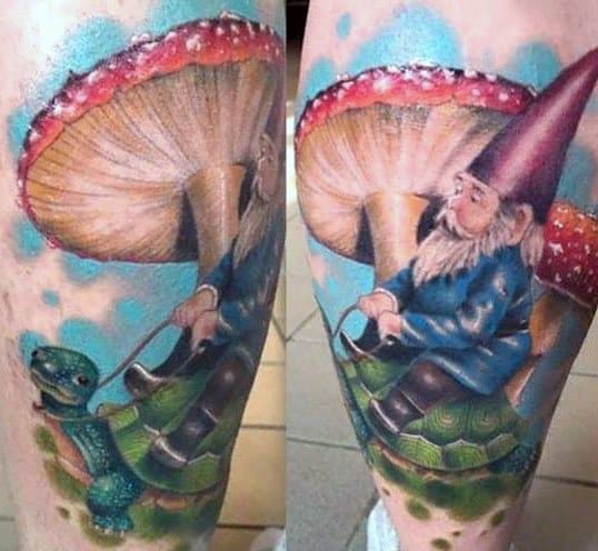 Colorful tattoo of a gnome with a red hat and blue coat riding a turtle, set against a whimsical backdrop of a giant mushroom and a blue sky.