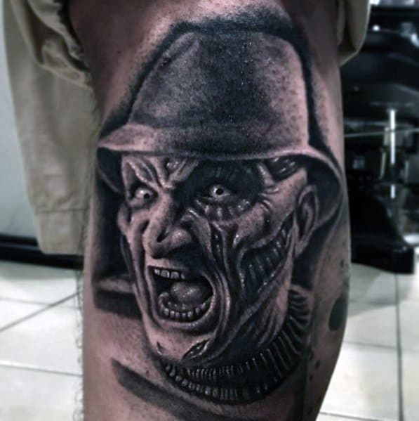 Black and grey tattoo of Freddy Krueger from *A Nightmare on Elm Street*, featuring his burned face, intense expression, and eerie shading for a chilling effect.