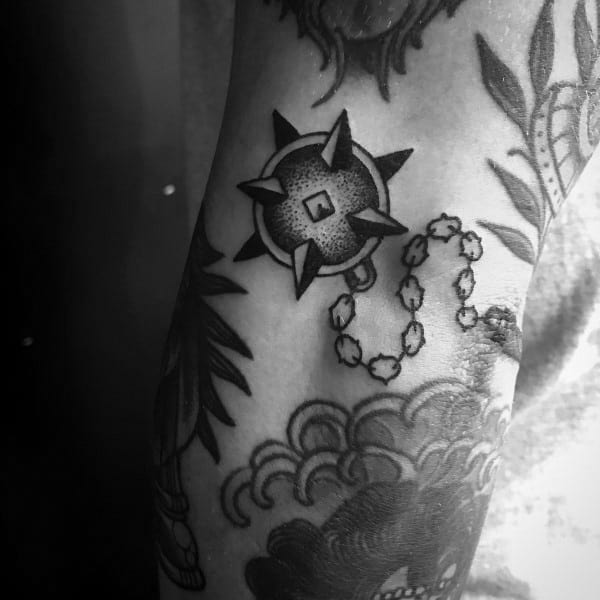 Black ink mace tattoo featuring a spiked ball on a chain, intricately shaded, symbolizing strength, resilience, and medieval weaponry.