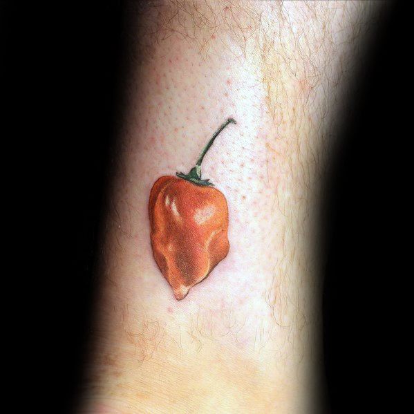 Realistic habanero pepper tattoo on the ankle with rich orange shading and a delicate green stem, creating a bold yet subtle design.