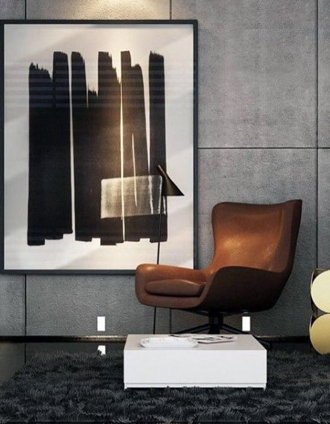 Modern interior with a brown armchair, abstract black-and-white painting, floor lamp, and textured rug