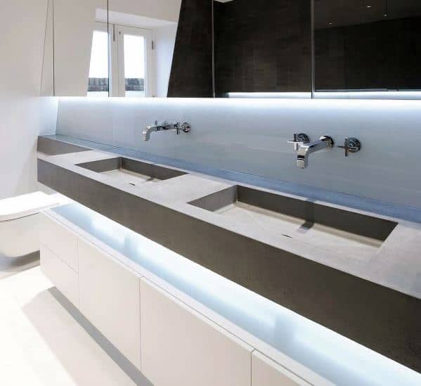Modern double bathroom vanity with concrete sinks, wall-mounted faucets, and LED lighting.