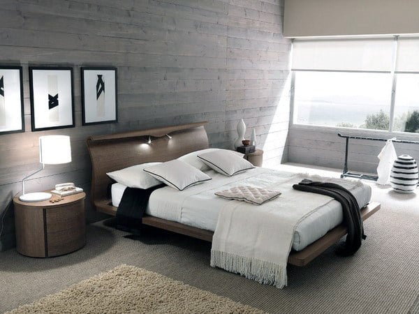 Modern bedroom with a large bed, wooden walls, and large window with natural light