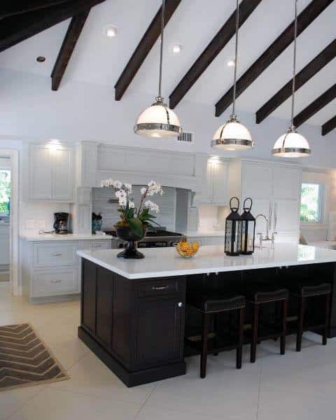 Black and white kitchen with vaulted ceiling and pendant lighting.