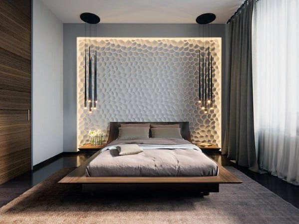 Modern bedroom with textured accent wall, platform bed, and low-hanging pendant lights.
