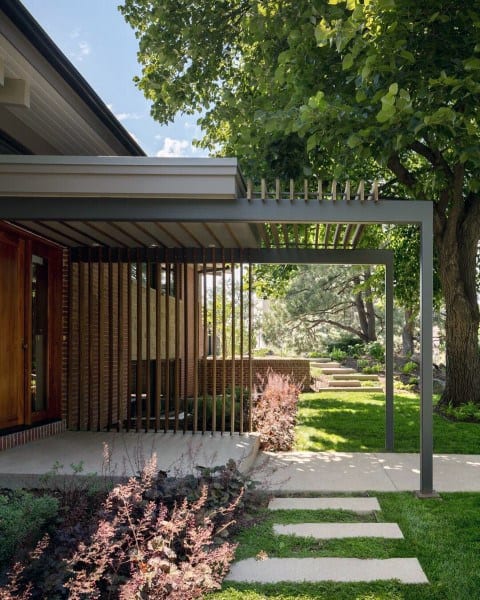 Contemporary pergola with vertical slats, metal frame, and integrated into a modern backyard design.