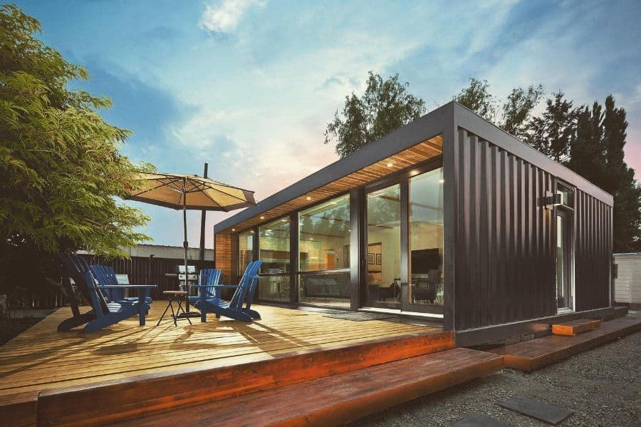 modern shipping container home with wood deck