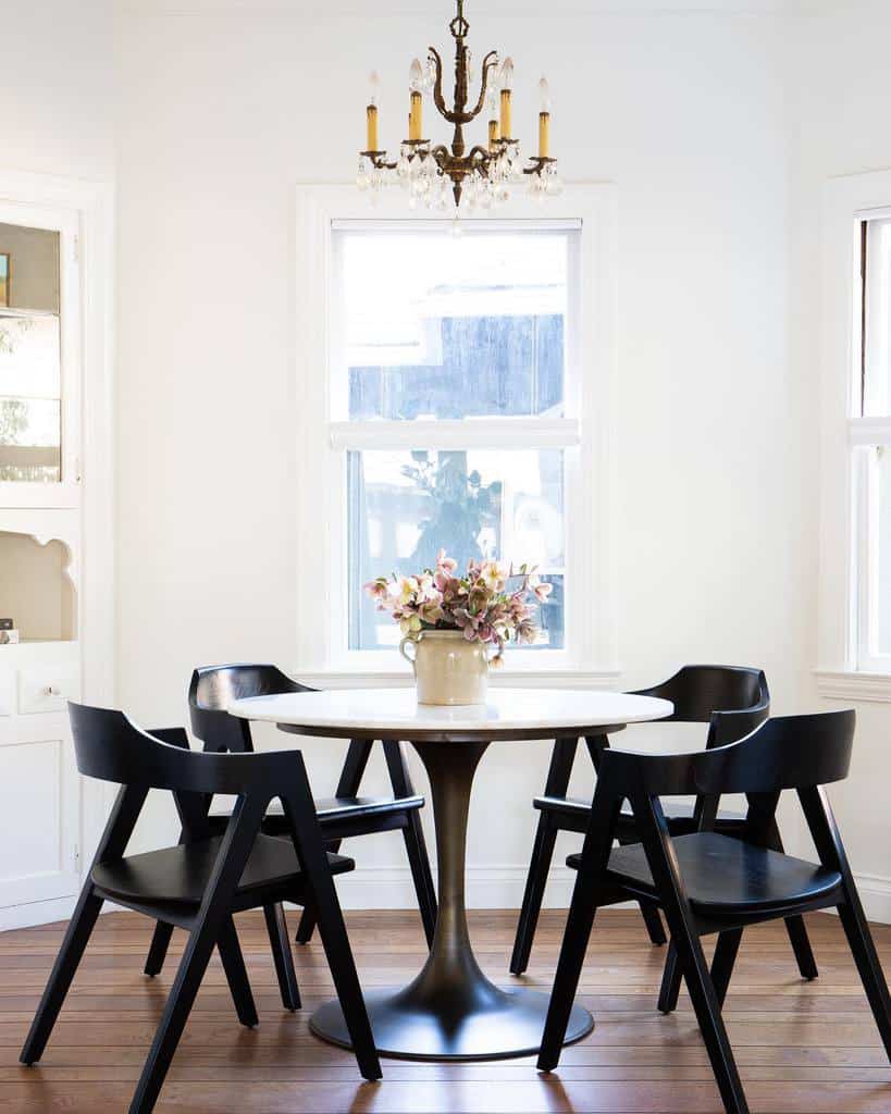 small dining room with white table and black chairs