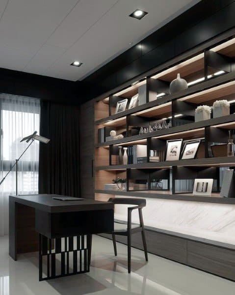 Modern home office with dark desk, illuminated shelves, and stylish minimalist decor.