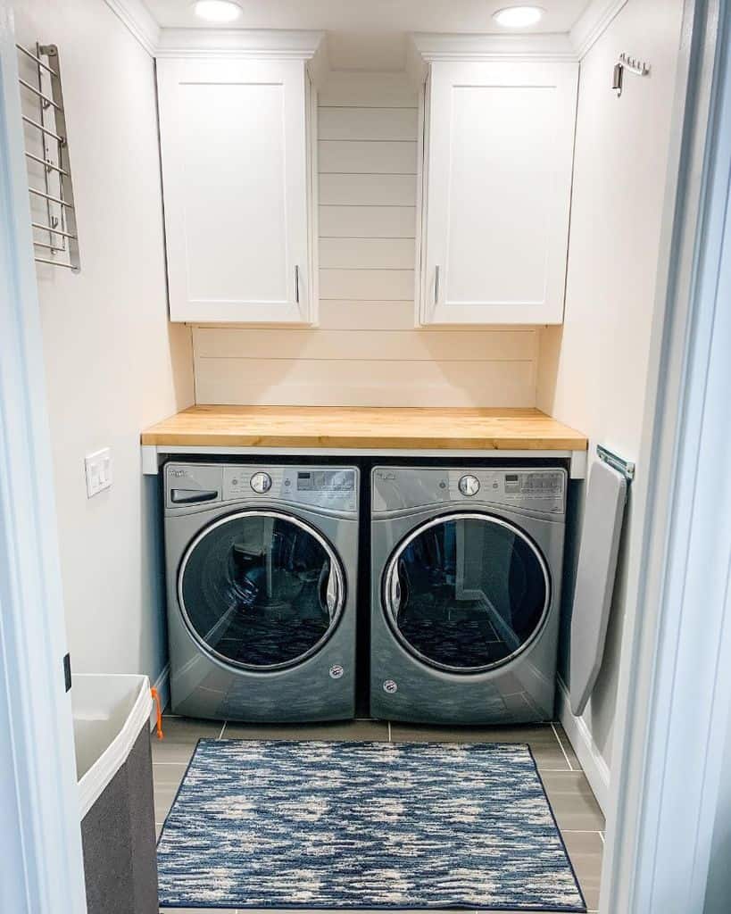 modern minimalist laundry with white wall cabinets