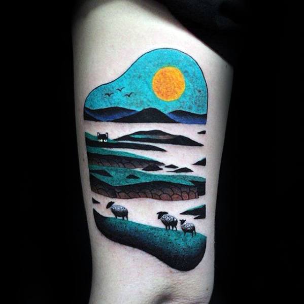 Tattoo of a landscape with hills, sheep, a house, and a bright sun or moon in the sky