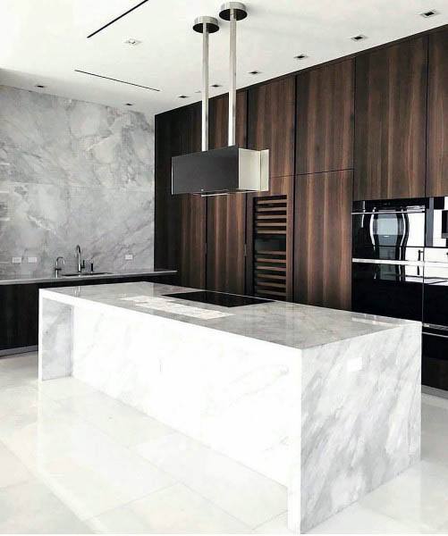 Minimalist kitchen with marble island, wood cabinets, and modern built-in appliances.