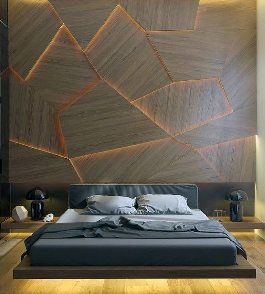 Luxury bedroom with geometric wood accent wall, low platform bed, and ambient lighting.