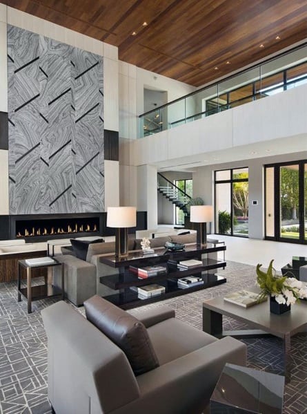 Modern living room with wood ceiling, large fireplace, and stylish gray furniture.