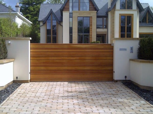 Modern driveway gate with horizontal wood plank design.