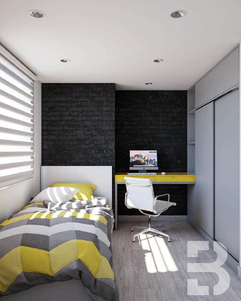 Modern bedroom with a single bed, bright yellow-striped bedding, a desk with a computer, and a white office chair