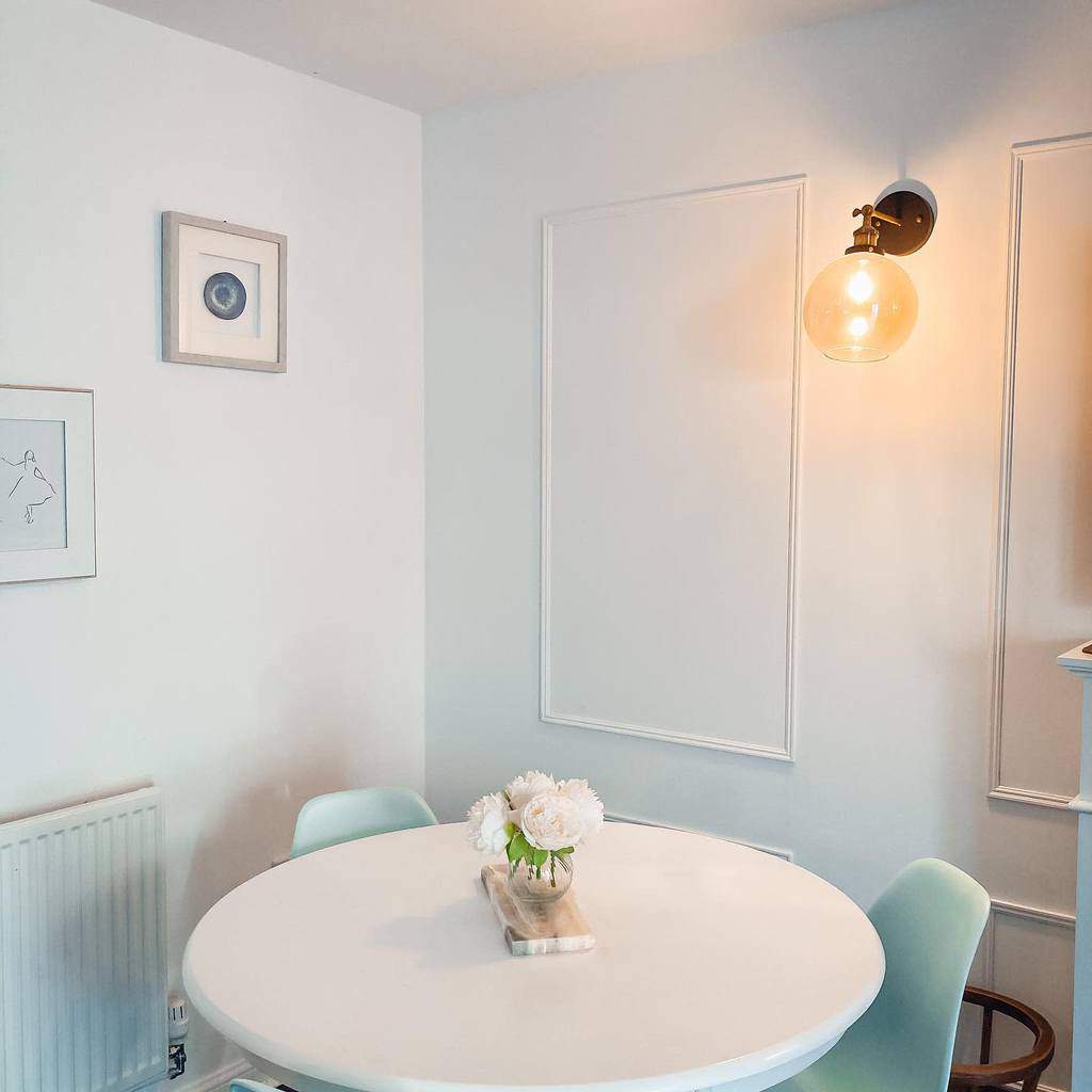 white molding dining room wall decor ideas small round table blue chairs scones wall lights 