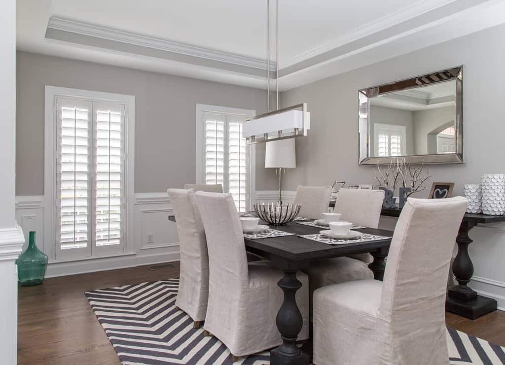 molding dining room table and chairs wall mirror black and white floor rug