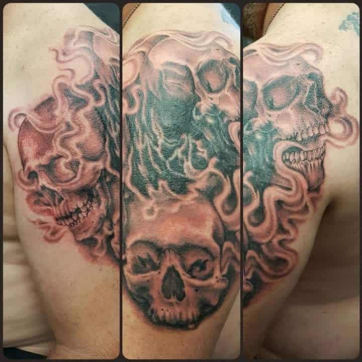 Tattoo of three skulls with flames on shoulder, showing different angles and details