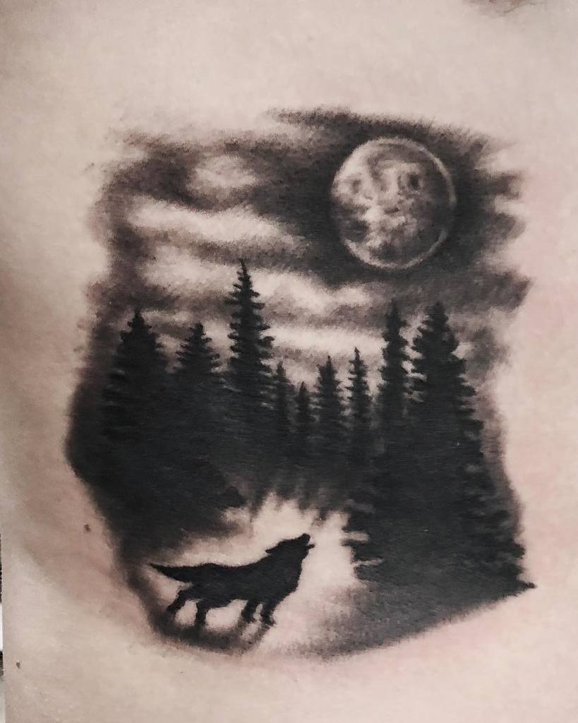 Tattoo of a wolf howling at the moon surrounded by pine trees