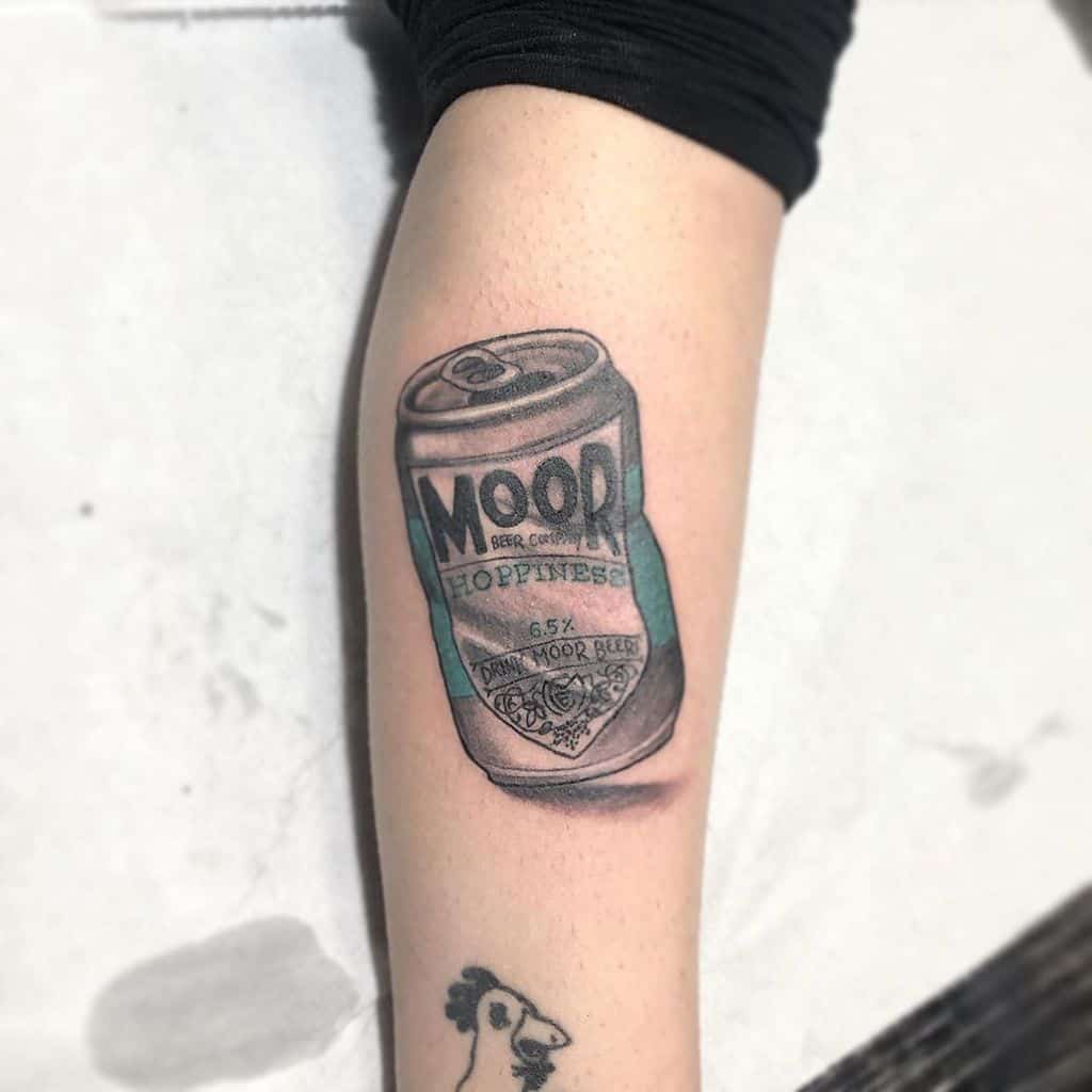 A realistic tattoo of a tilted beer can labeled 'MOOR HOPPINESS' with shading that creates a 3D effect, placed on the forearm.