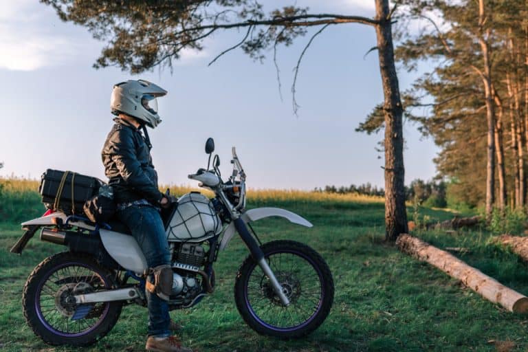 motorcyclist with his bike, sunset outdoor view