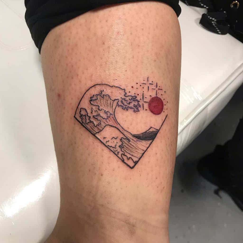 Minimalist tattoo featuring a stylized ocean wave inside a geometric shape, with a red sun and fine line