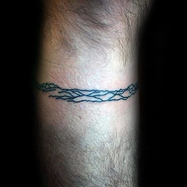 Minimalist mountain landscape tattoo around a forearm