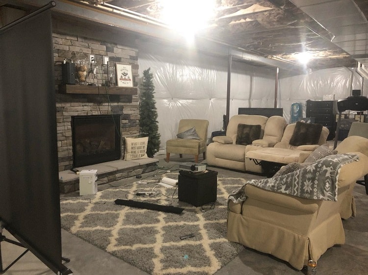basement movie room stone fireplace projector sofa and recliners 