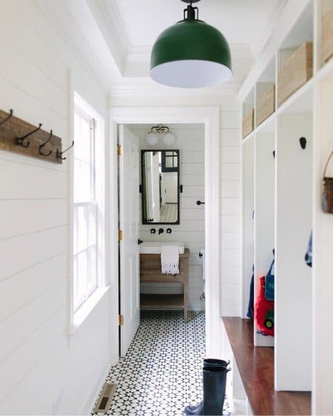 narrow mudroom with white cabinets and bench seating