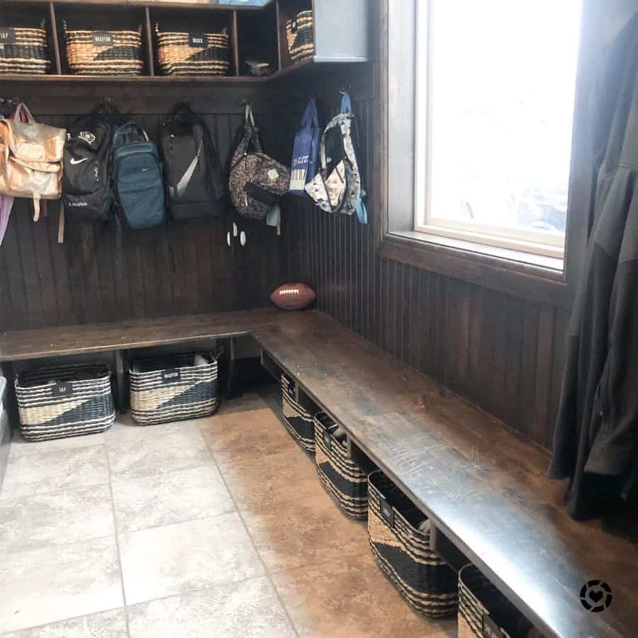 well organized wood mudroom with bench seating and hooks
