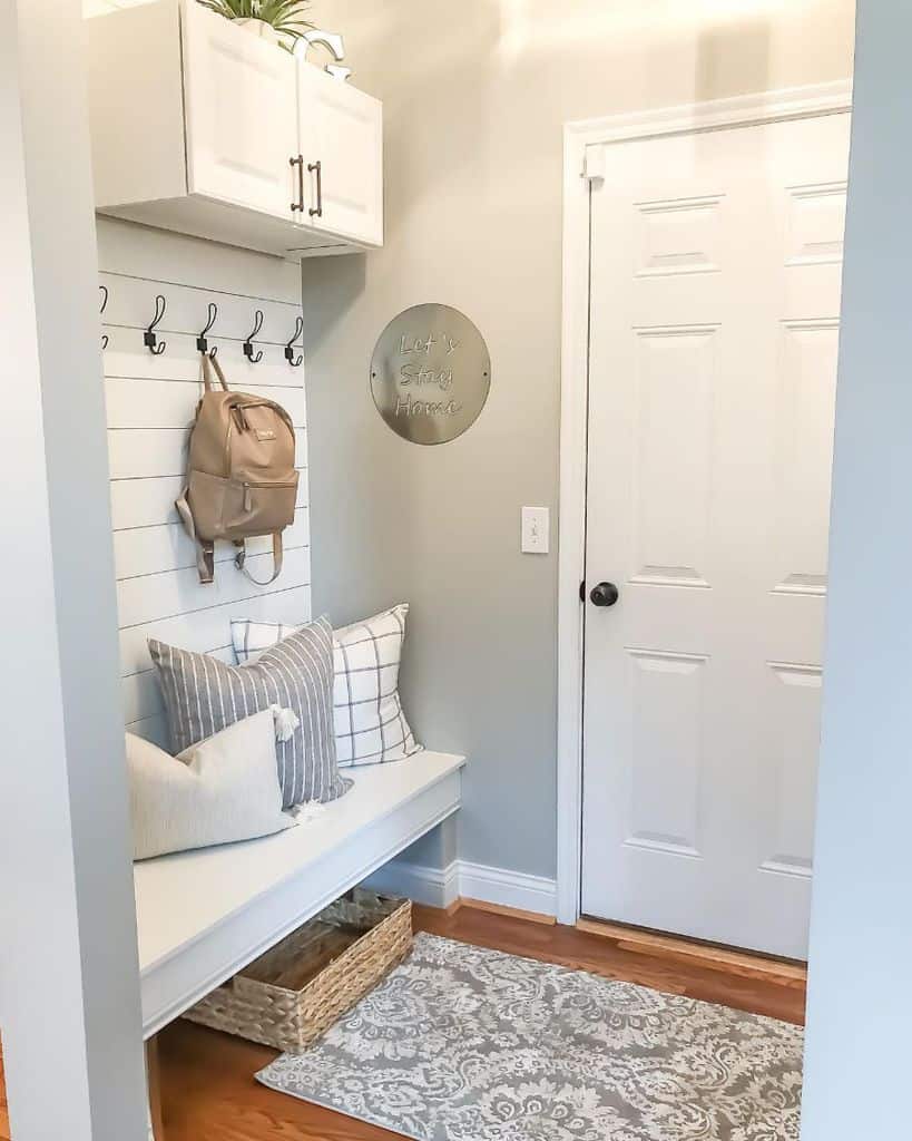 small mudroom with bench seat, hooks and cabinet storage