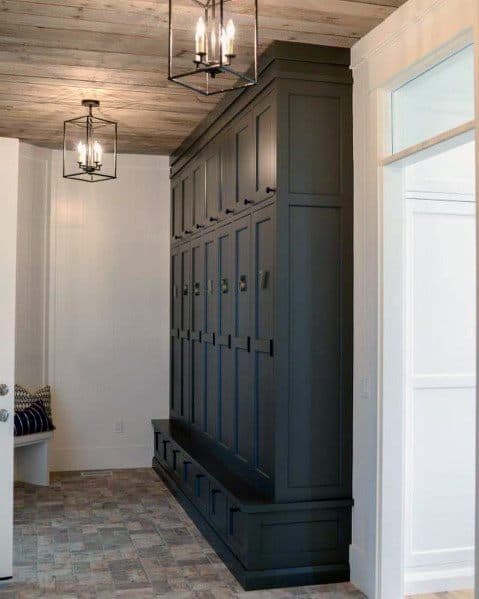 Mudroom with rustic wood ceiling, dark built-in lockers, and industrial pendant lighting.