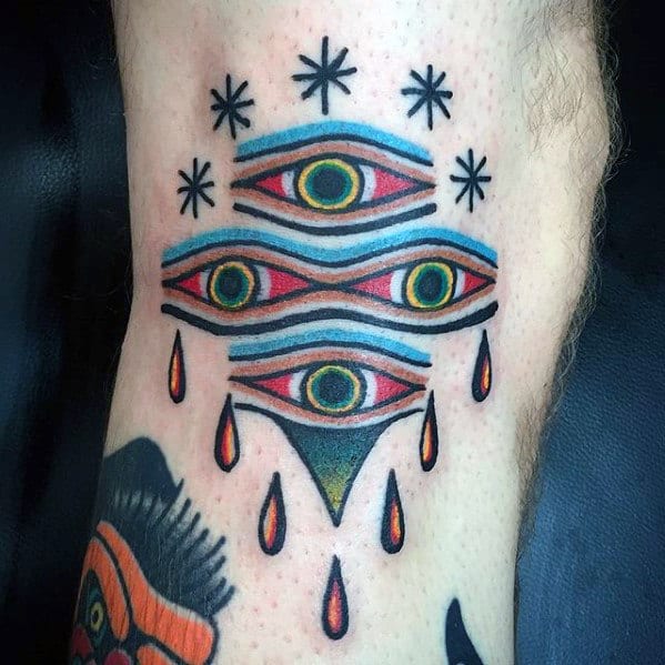 Tattoo of multiple eyes with tears and stars on skin