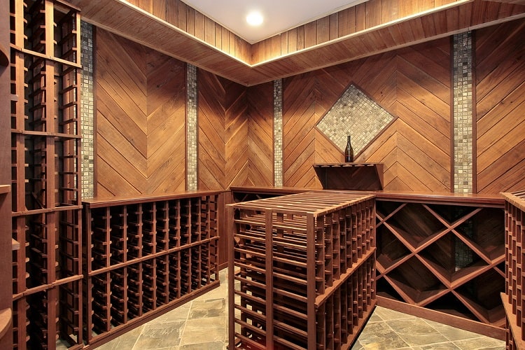 Wood-paneled wine cellar with multiple wooden racks and geometric wall accents.