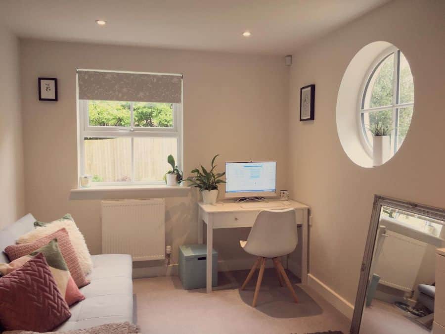 small office with white desk blue couch mirror
