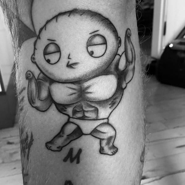 Tattoo of Stewie Griffin from Family Guy with an exaggerated muscular body, flexing his biceps in a black and gray shading style.