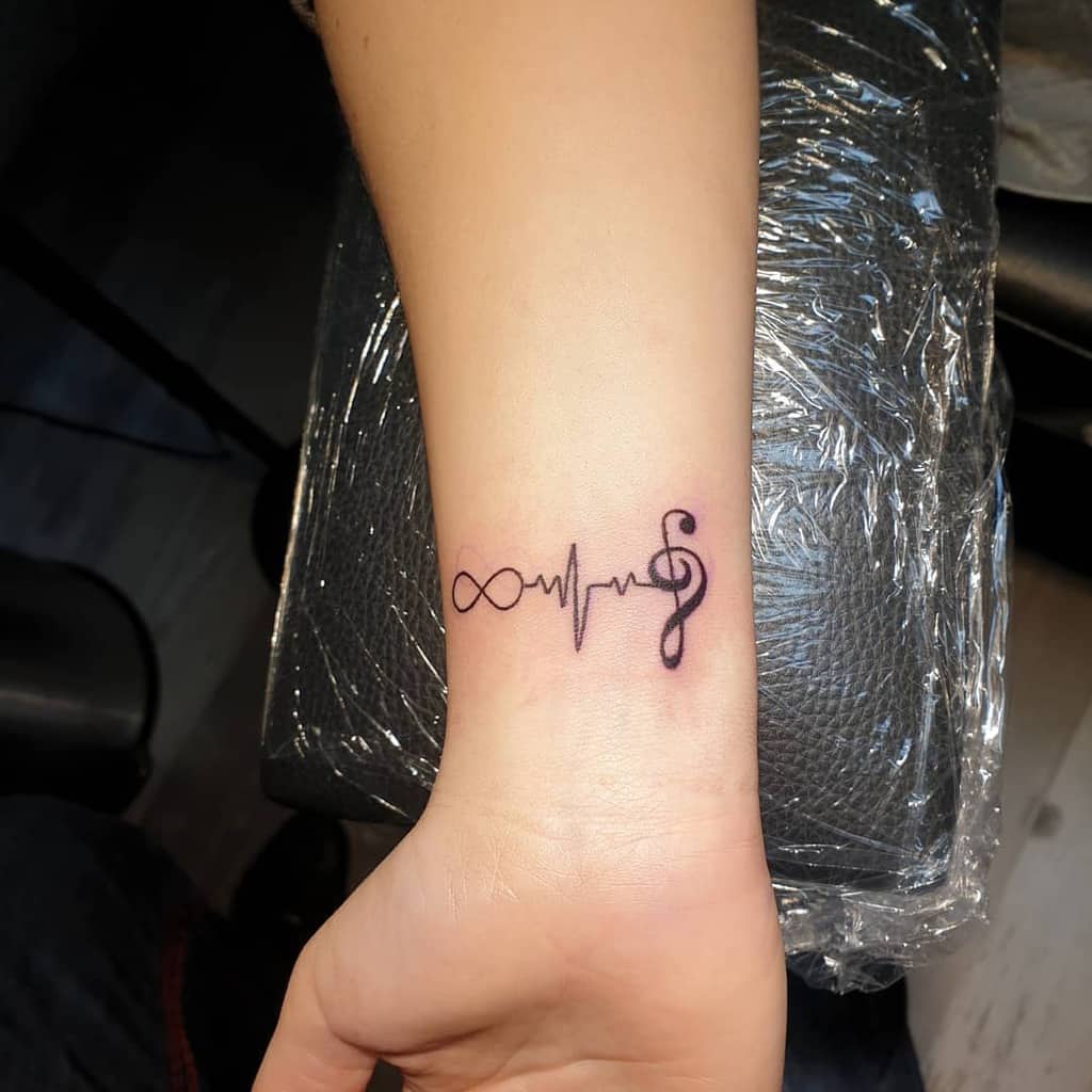 A creative tattoo combining an infinity symbol, a heartbeat line, and a musical note, reflecting the connection between life, music, and eternity.