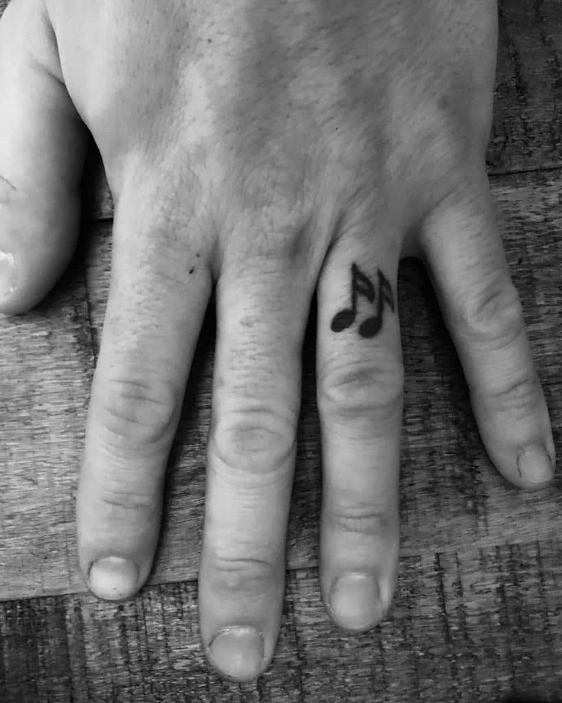 A wedding ring tattoo of musical notes, symbolizing a love for music or a special connection with melody