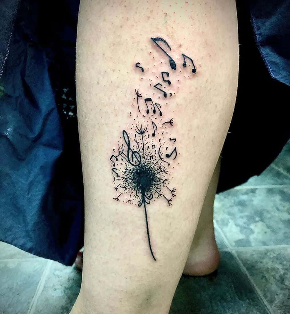 Creative dandelion tattoo on the leg with seeds transforming into musical notes, symbolizing harmony, creativity, and the power of music.
