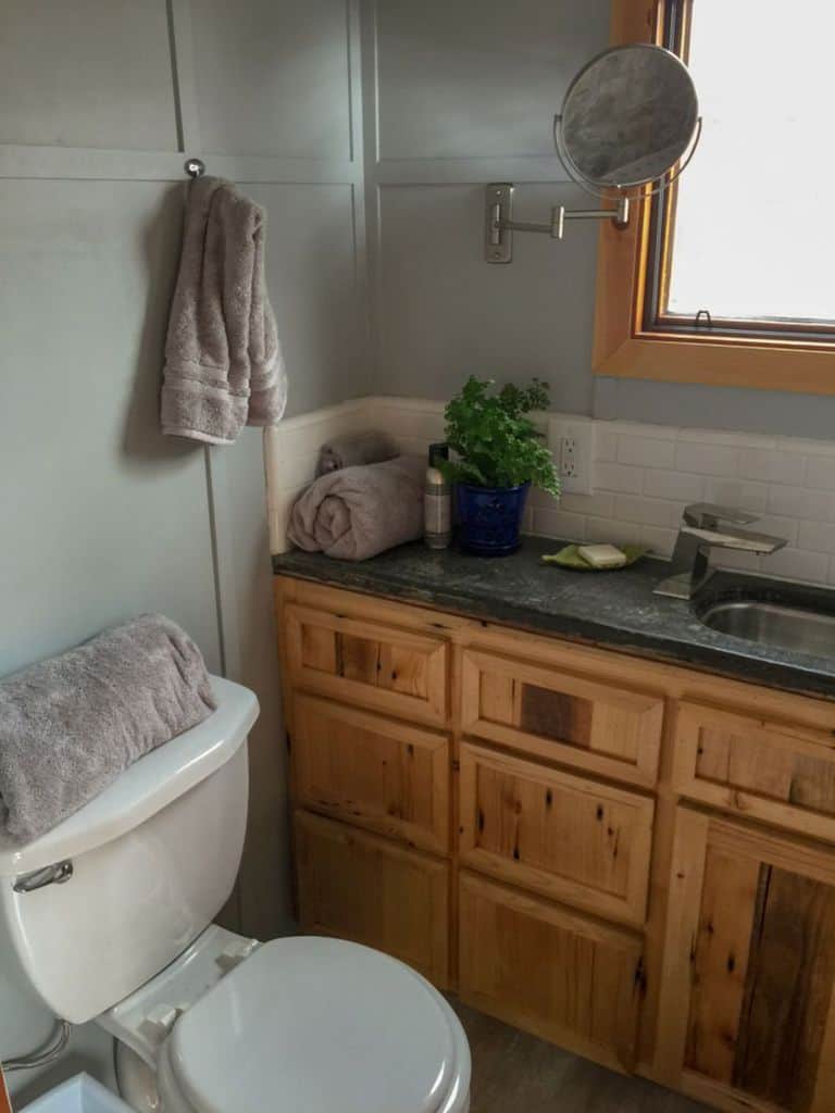 muted green bathroom with wood vanity 