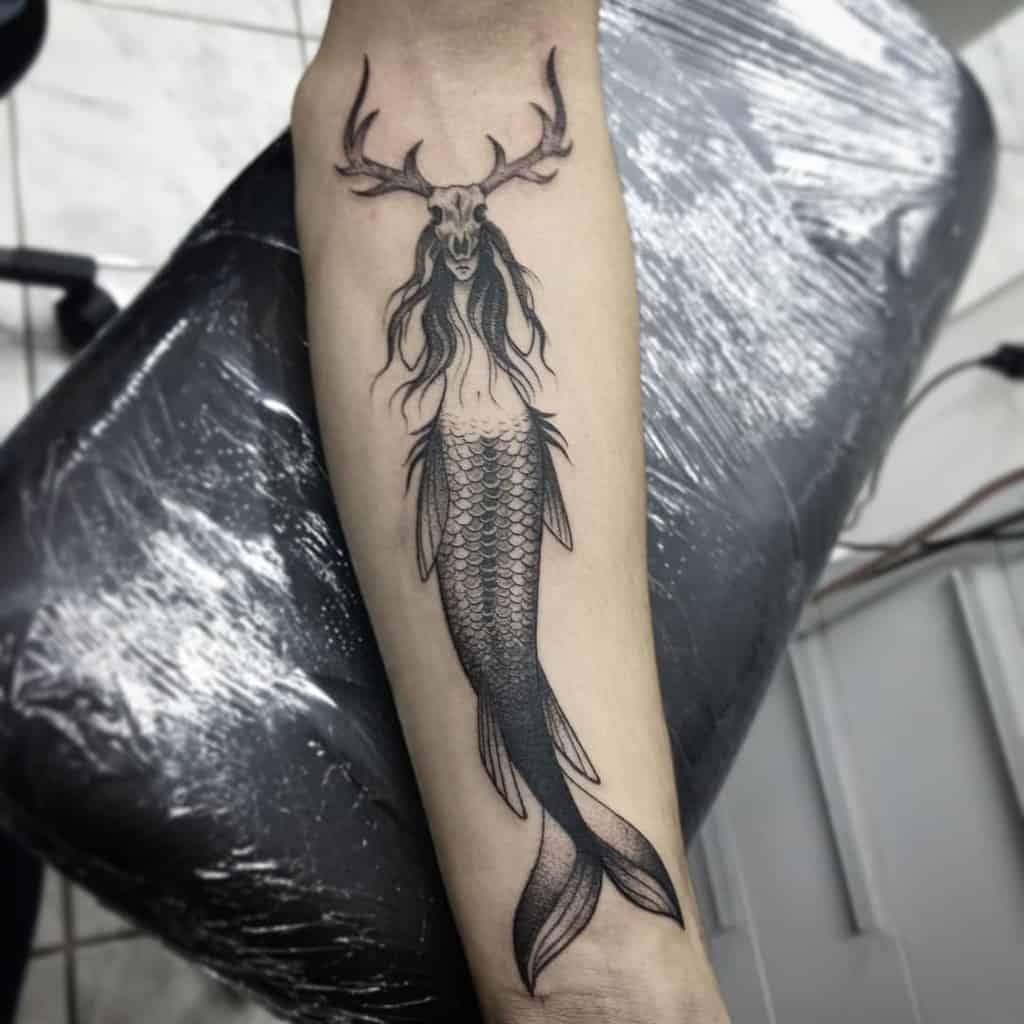 Tattoo of a siren with deer antlers on a forearm