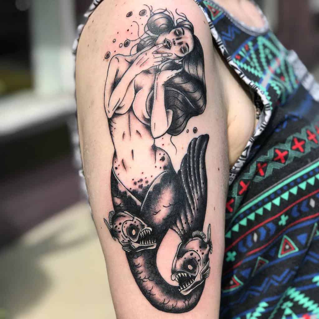 Dark fantasy tattoo of a siren with flowing hair, surrounded by anglerfish, combining beauty and eerie underwater elements