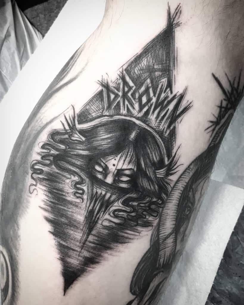 Black and white tattoo of a mysterious, hooded siren with flowing hair, geometric background, and stylized text